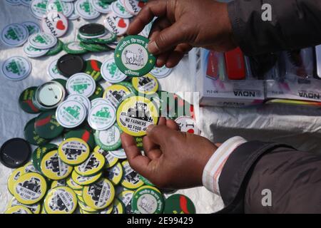 A protester holding pin badges during the demonstration.Farmers continue with their demonstration for the 70th Day. Thousands of farmers especially from Punjab and Haryana protest against the new three farm laws and also demand rollback of the laws and guarantee of the Minimum Support Price (MSP). Indian Government deployed huge police and armed forces, and suspended internet services in the Delhi-border area. Stock Photo