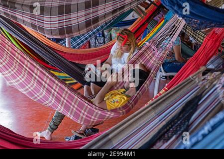 Tourists / passengers resting in hammocks on board of passenger and cargo vessel / ferry boat on the Amazon river in Brazil Stock Photo