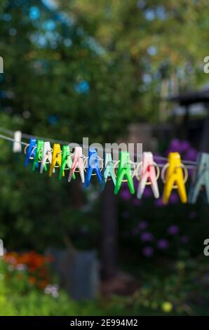 Multicolored clothespins on a natural blurred background vertical orientation Stock Photo