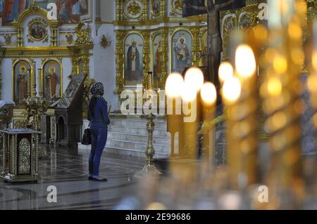 A woman in a temple. Interior of the Orthodox Church. A person prays in a church. Stock Photo