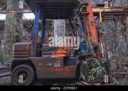 Rusty old stacker truck abandoned on an old warehouse Stock Photo