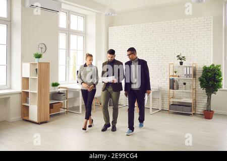 Office workers on the go review documents and discuss new business development strategies and plans. Stock Photo