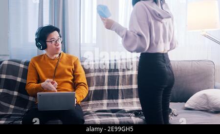 Young couple having an argument. Woman screaming on the man playing games on laptop. High quality photo Stock Photo