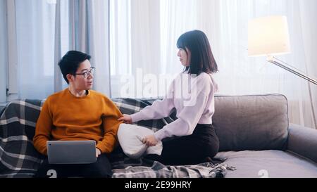Young woman seeking attention of her boyfriend who is working on laptop. High quality photo Stock Photo