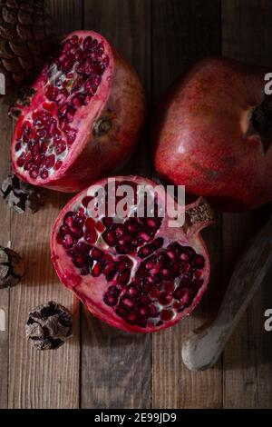 Ripe pomegranate fruits on the wooden background. Stock Photo