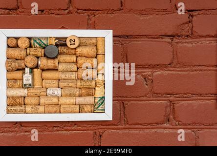 Minsk, Belarus - February 01, 2021: Decorating a creative space with wine corks from different countries on red brick Stock Photo