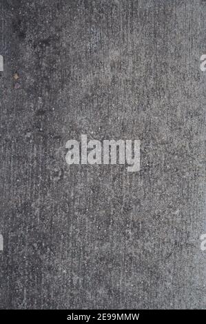 Direct overhead shot of the rough texture of light gray concrete with vertical lines imprinted into it. Stock Photo