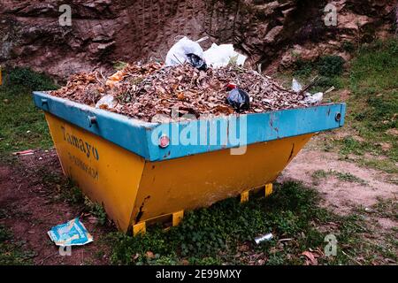 A yellow skip full of dead leaves. Stock Photo