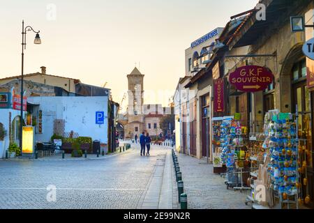LARNACA, CYPRUS - FEB 18, 2019: Couple walking by a street full of tourist shops to the Saint Lazarus church in Larnaca, Cyprus Stock Photo