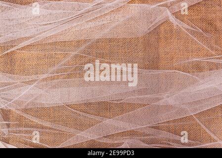 jute fabric texture background with white curtain above. top view of linen and textile pattern with soft natural light. rustic hessian fabric Stock Photo
