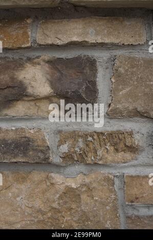 Close-up photo of a rough, natural-stone wall with gray grout. Stock Photo
