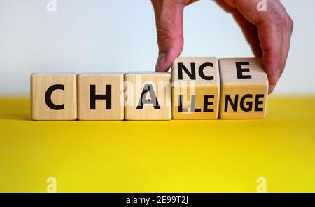 Challenge or chance symbol. Businessman turns cubes and changes the word 'challenge' to 'chance'. Beautiful yellow table, white background, copy space Stock Photo