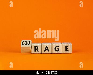 Rage or courage symbol. Turned a cube and changed the word 'rage' to 'courage'. Beautiful orange background. Copy space. Business and rage or courage Stock Photo