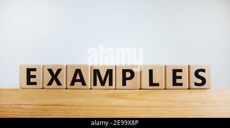Examples symbol. Concept word 'examples' on wooden cubes on a beautiful wooden table. White background. Business and examples concept. Stock Photo