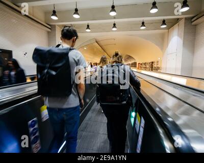 Paris, France - Oct 13, 2018: Parisian underground metro scene with few commuters people on the escalator taking the fastest route to interchanges with other lines