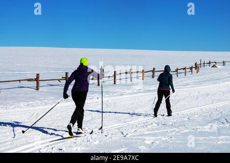 Two women cross country skiing in snowy plain Winter scene Stock Photo