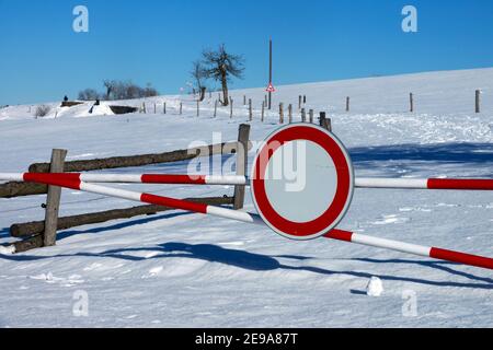 Traffic sign - no entry on a road that is not maintained in winter, snow covered rural Czech Republic road snowdrift scenery Stock Photo