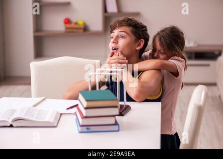 Teenager and his small sister staying at home during pandemic Stock Photo