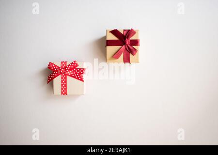Two small gift boxes with tied decorative bow and red ribbon on white background.Holidays present concept. Stock Photo