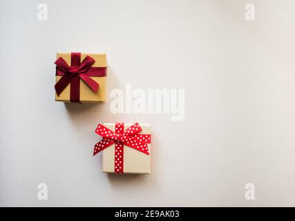 Two small gift boxes with tied decorative bow and red ribbon on white background.Holidays present concept. Stock Photo