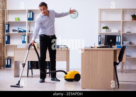 Young employee businessman cleaning office during pandemic Stock Photo