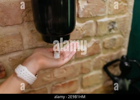 Cleaning, washing hands using automatic sanitizer dispenser concept. Stock Photo