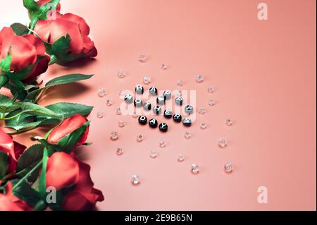 Mother's Day message with red Roses over orange color Background. Top view. Stock Photo