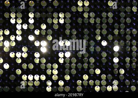 Background sequin. Holiday abstract glitter background with blinking lights. Fashion fabric glitter sequins background Stock Photo