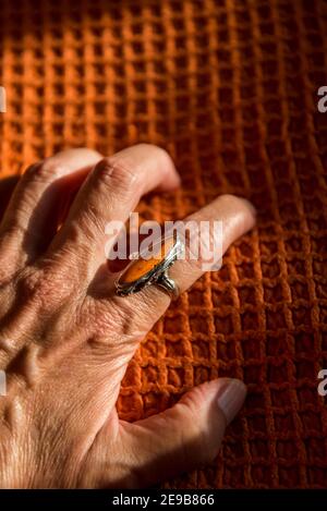 Female hand gripping an orange ring on an orange cover Stock Photo