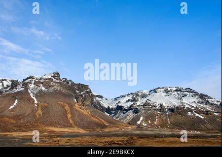 Icelandic tundra landscape, Skaftafell National Park with snow capped mountain background and blue cloud sky