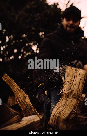 Chopping logs for firewood in action and close up with particles flying Stock Photo