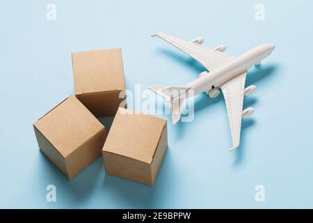 Toy plane and cardboard boxes on a blue background. Cargo delivery concept. Stock Photo
