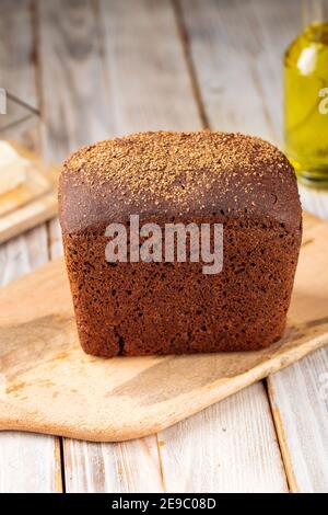 Loaf of rye bread on the wooden cutting board Stock Photo