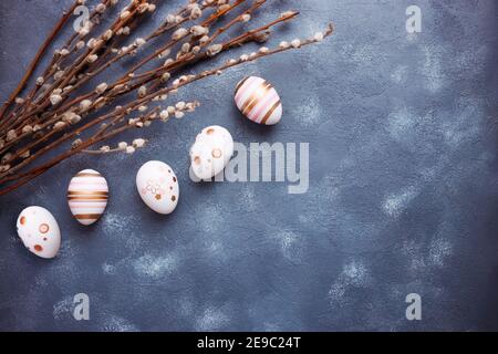 Easter greeting card concept. Easter eggs with willow branches on blue art background. Flat lay, copy space, top view Stock Photo