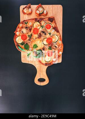 Delicious vegetarian heart shaped pizza with tomatoes, vegetables and cheese for Valentine's Day on black background. concept of romantic love Stock Photo