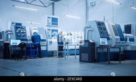 Modern Factory with Professional Workers, Engineers, Managers Working on Production Line, Workshop Management, Optimization. Industrial Facility Stock Photo
