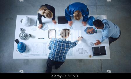 Team of Industrial Engineers Lean on Office Table, Analyze Machinery Blueprints, Architectural Problem Solving, Consult Project on Tablet Computer Stock Photo