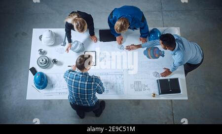 Team of Industrial Engineers Lean on Office Table, Analyze Machinery Blueprints, Architectural Problem Solving, Consult Project on Tablet Computer Stock Photo