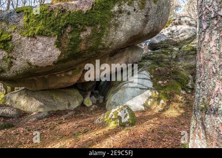 Ancient weathered megalithic granite rock formation with cave and breakthrough in Bavarian forest near Thurmansbang, Germany Stock Photo