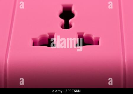 Closeup picture of a pink outlet isolated on black. Electric Power Line ...