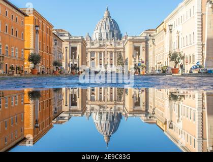 Frequent rain showers create pools in which the wonderful Old Town of Rome reflects like in a mirror. Here in particular the St. Peter's Basilica Stock Photo