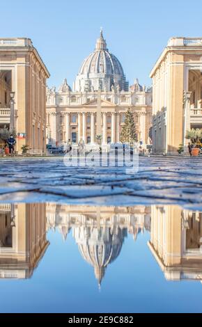 Frequent rain showers create pools in which the wonderful Old Town of Rome reflects like in a mirror. Here in particular the St. Peter's Basilica Stock Photo