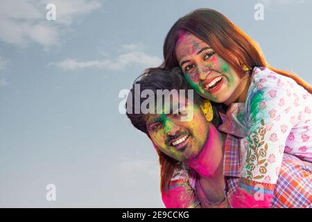 A HAPPY COUPLE POSING TOGETHER WHILE CELEBRATING HOLI Stock Photo