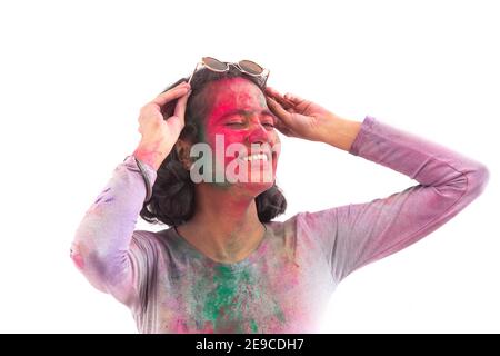 A HAPPY YOUNG WOMAN POSING IN FRONT OF CAMERA DURING HOLI Stock Photo