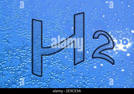 wavy h2 hydrogen letters with lot of circles in blue water Stock Photo