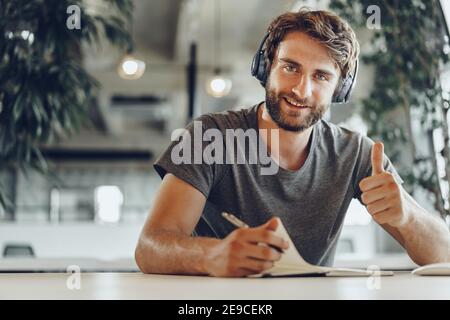 Bearded man freelance worker making notes in his notepad Stock Photo