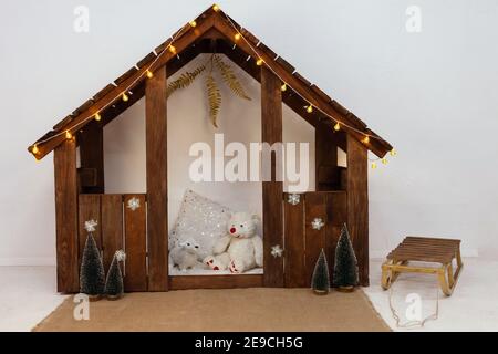 Children's home, Christmas. New Year's photo zone, sled, soft toys, Christmas trees, snowflakes and yellow garland. Children's photo zone in the studi Stock Photo