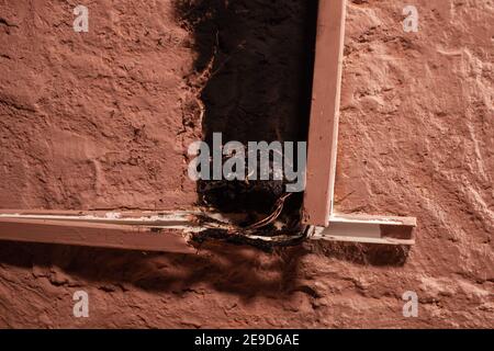 Short circuit, burnt wires. traces of smoke and fire on the wall. The electrical outlet was completely burnt and melted, the voltage drop from the use Stock Photo