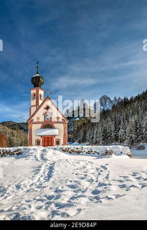 Scenic winter view over St Johann in Ranui church with Odle Dolomites behind, Val di Funes, Alto Adige - South Tyrol, Italy Stock Photo