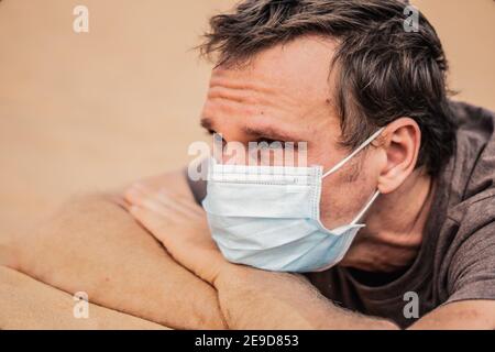 Side portrait young man wear protective mask, face expression emotion. Concept COVID stress syndrome, mental health, fear of danger contamination Stock Photo